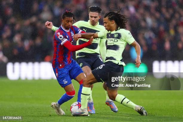 Michael Olise of Crystal Palace is challenged by Nathan Ake of Manchester City during the Premier League match between Crystal Palace and Manchester...