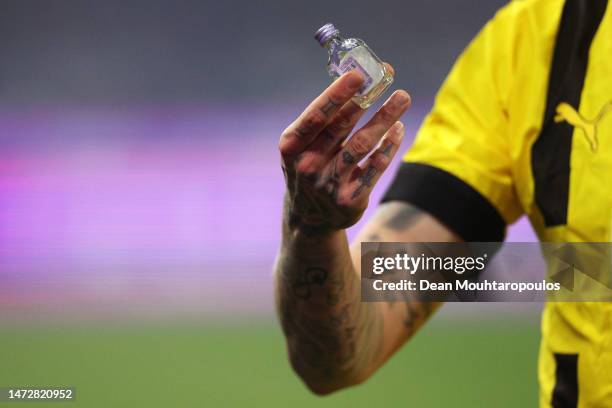 Marius Wolf of Borussia Dortmund holds up a bottle which has been thrown on to the pitch by FC Schalke 04 fans during the Bundesliga match between FC...