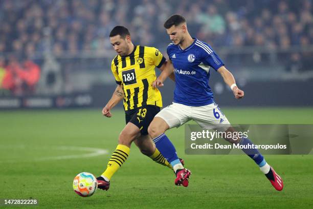 Raphael Guerreiro of Borussia Dortmund battles for possession with Tom Krauss of FC Schalke 04 during the Bundesliga match between FC Schalke 04 and...