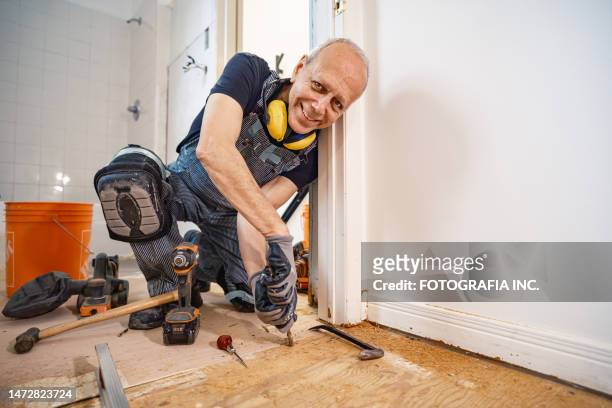 älterer kaukasischer mann bei der baurenovierung im innenbereich - handyman stock-fotos und bilder