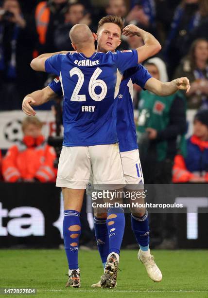 Marius Buelter of FC Schalke 04 celebrates with teammate Michael Frey after scoring the team's first goal during the Bundesliga match between FC...