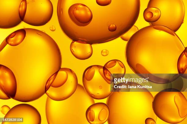 transparent yellow, gold molecules, oil drops. beauty 3d pattern. cosmetic products for makeup and skin care. collagen. - oily skin stock pictures, royalty-free photos & images