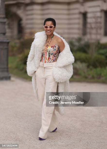 Tamu McPherson is seen wearing a white fluffy coat, beige wide leg pants, a flower printed corsage and sunglusses before the Zimmermann show on March...