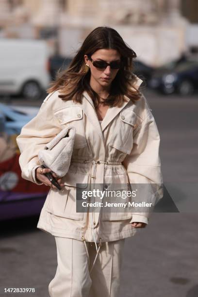 Fashion week guest seen wearing dark sunglasses, a beige jacket, matching beige pants and a fluffy bag before the Zimmermann show on March 06, 2023...