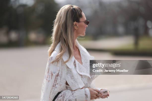 Fashion week guest seen wearing a white semi sheer dress, a black bag and sunglasses before the Zimmermann show on March 06, 2023 in Paris, France.