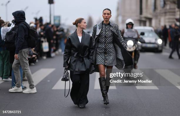 Sophia Roe is seen wearing a black leather suit, white shirt and black boots and a Louis Vuitton handbag and a guest is seen wearing a dark grey with...