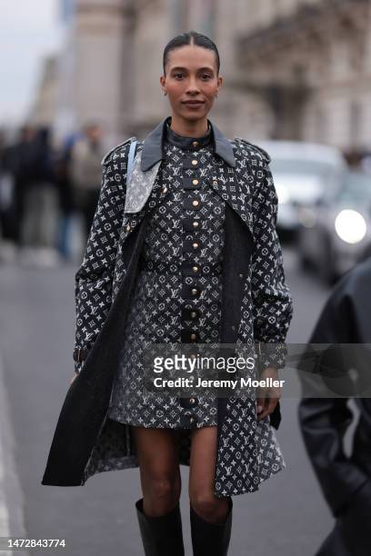 Guest is seen wearing a dark grey with white embroidered Louis Vuitton monogram print patterned dress, a matching long Louis Vuitton coat, a pale...