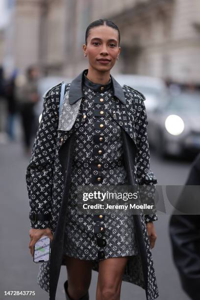 Guest is seen wearing a dark grey with white embroidered Louis Vuitton monogram print patterned dress, a matching long Louis Vuitton coat, a pale...