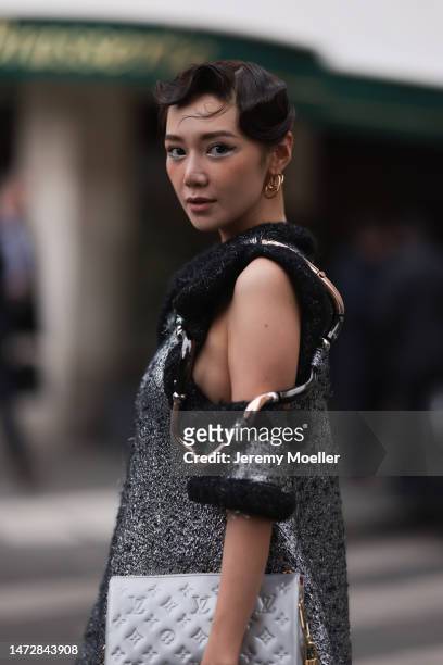 Fashion Week guest is seen wearing gold Louis Vuitton earrings, a silver and black wool with wavy large borders and cut-out shoulders Louis Vuitton...