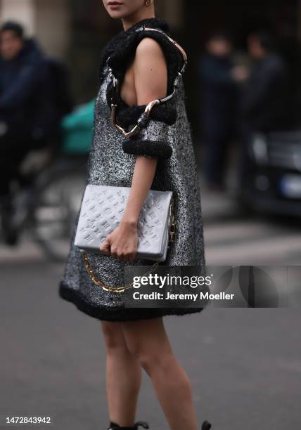 Fashion Week guest is seen wearing gold Louis Vuitton earrings, a silver and black wool with wavy large borders and cut-out shoulders Louis Vuitton...