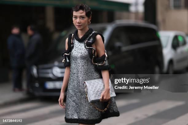 Fashion Week guest is seen wearing gold Louis Vuitton earrings, a silver and black wool with wavy large borders and cut-out shoulders Louis Vuitton...