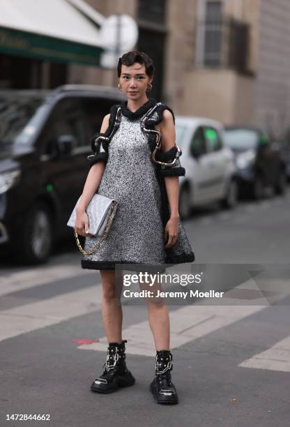 Fashion Week guest is seen wearing gold Louis Vuitton earrings, a silver and black wool with wavy large borders and cut-out shoulders Louis Vuitton...