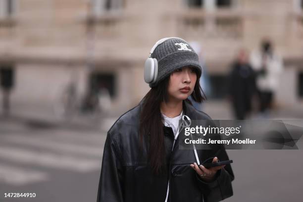 Fashion Week guest is seen wearing a black leather jacket, white shirt, and grey hat outside the Louis Vuitton show during Paris Fashion Week on...