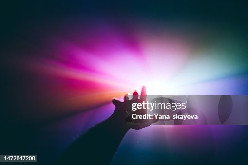 Intergalactic human journey concept with an arm reaching out to the bright vibrant multicolor light Intergalactic human journey concept with an arm reaching out to the bright vibrant multicolor light