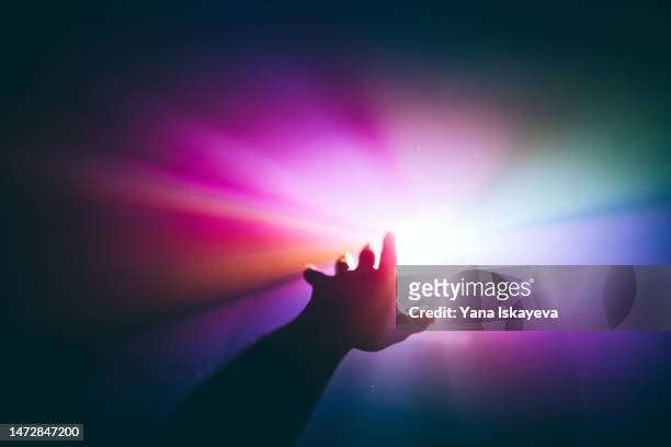 intergalactic human journey concept with an arm reaching out to the bright vibrant multicolor light - voorspellen stockfoto's en -beelden