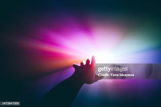 intergalactic human journey concept with an arm reaching out to the bright vibrant multicolor light - dreams stock pictures, royalty-free photos & images