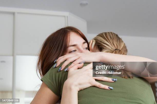 forgiveness - supporting mother and hugging daughter - unhappy teen stock-fotos und bilder