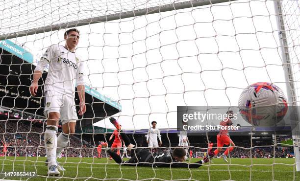 Brighton player Alexis Mac Allister heads the first goal past Leeds goalkeeper illan Meslier as Max Wober reacts on the line during the Premier...