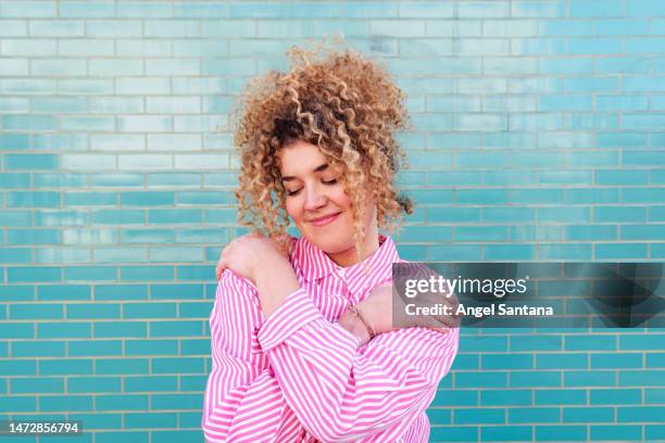 a radiant woman wrapped in her own loving arms - world mental health day ストックフォトと画像