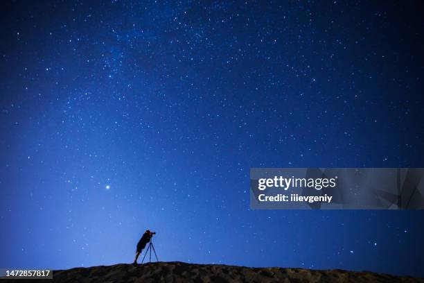 夜空の写真を撮る写真家。夜の星空の背景に男のシルエット。星 - 望遠鏡　男性 ストックフォトと画像