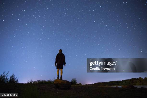 silhouette des menschen vor dem hintergrund des nächtlichen sternenhimmels. sterne - weltraum und astronomie stock-fotos und bilder