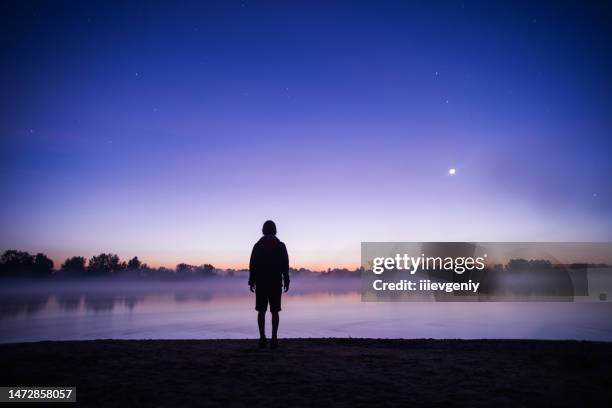 silhouette of man against background of night starry sky. stars - water crisis stock pictures, royalty-free photos & images