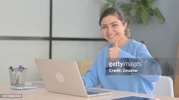 thumbs up indian woman working laptop