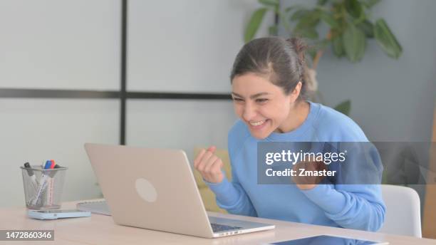 Indian Woman Celebrating Online Success on Laptop in Office indian woman celebrating online success laptop