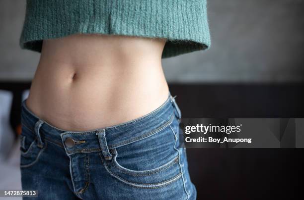 close up of woman with slim waist. conceptual shot of woman showing her diet results. - kort topp bildbanksfoton och bilder