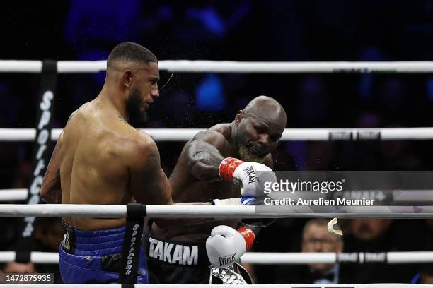 Carlos Takam of Cameroon punches Tony Yoka of France which knocks out his mouth guard during the international heavyweight contest boxing match in...