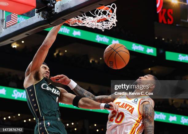 Jayson Tatum of the Boston Celtics dunks against John Collins of the Atlanta Hawks during the second quarter at State Farm Arena on March 11, 2023 in...