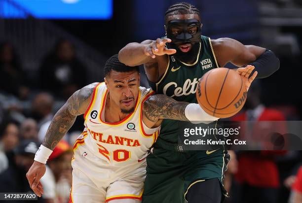 Jaylen Brown of the Boston Celtics steals the ball from John Collins of the Atlanta Hawks during the first quarter at State Farm Arena on March 11,...