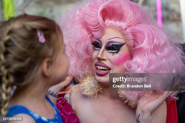 Drag Queen Brigitte Bandit speaks with Keanya Philyan during a story time reading at the Cheer Up Charlies dive bar on March 11, 2023 in Austin,...