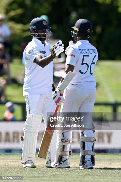 Angelo Mathews and Dinesh Chandimal of Sri Lanka shake hands after scoring a 100 run partnership during day four of the First Test match in the...