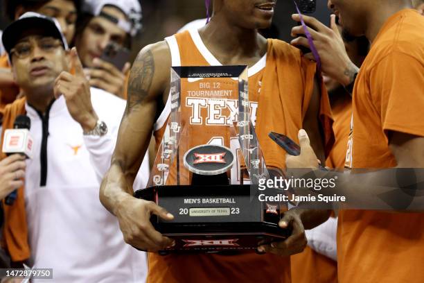 Sir'Jabari Rice of the Texas Longhorns hold the trophy after defeating the Kansas Jayhawks in the Big 12 Tournament Championship game at T-Mobile...