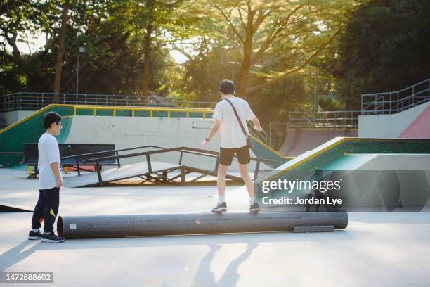 boy balancing on log in playground - playground balance beam stock pictures, royalty-free photos & images