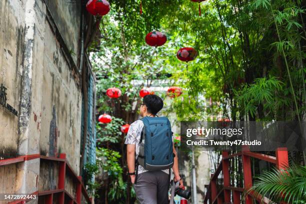 a backpacker traveling in a china town in kuala lumpur city - kuala lumpur culture stock pictures, royalty-free photos & images