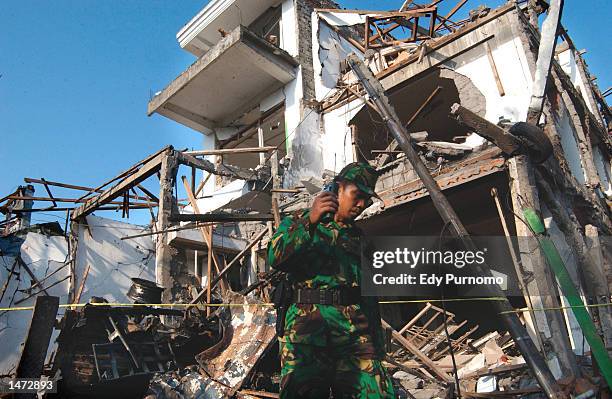 An Indonesian soldier walks through the rubble of the bomb blast at a Bali nightclub October 13, 2002 in Denpasar Bali, Indonesia. The blast occurred...