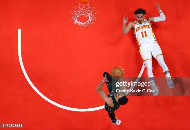 Trae Young of the Atlanta Hawks falls to the floor as Derrick White of the Boston Celtics drives to the basket during the fourth quarter at State...