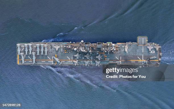 aerial view/a fighter aircraft carrier sailing in the middle of the sea. - buque de guerra fotografías e imágenes de stock