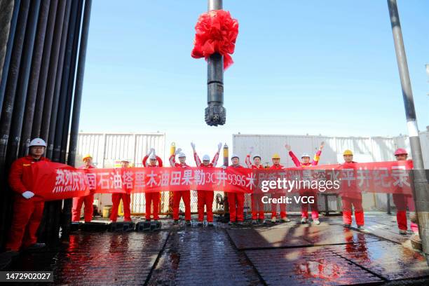 Oil workers hold a banner at Tarim Oilfield at Taklimakan Desert in Shaya County on March 9, 2023 in Aksu Prefecture, Xinjiang Uygur Autonomous...