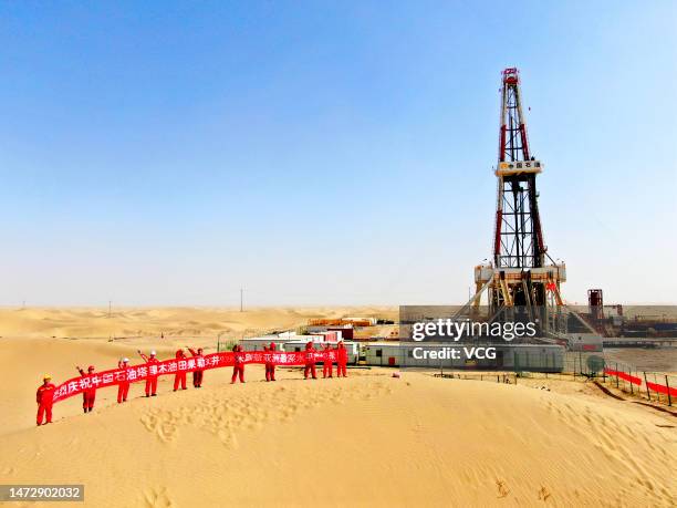 Aerial view of oil workers holding a banner at Tarim Oilfield at Taklimakan Desert in Shaya County on March 9, 2023 in Aksu Prefecture, Xinjiang...