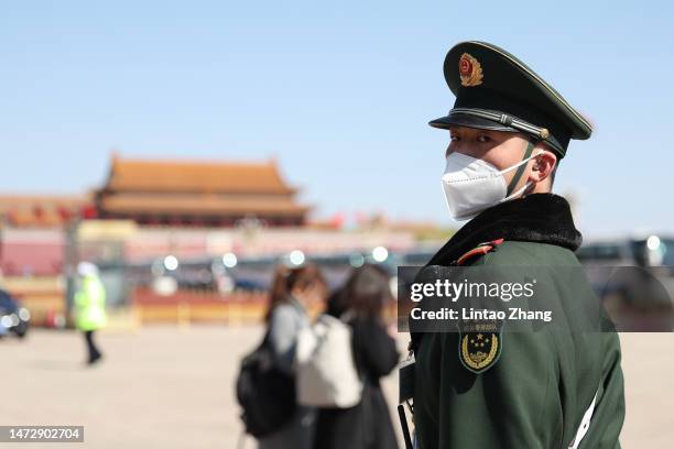 Security officer patrols in front of the Great Hall of the People during the fifth plenary session of the National People's Congress on March 12,...