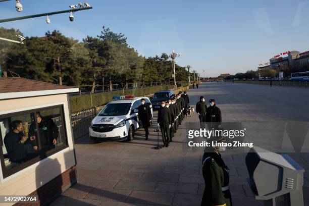 Security officers walk outside the Great Hall of the People ahead of the fifth plenary session of the National People's Congress on March 12, 2023 in...