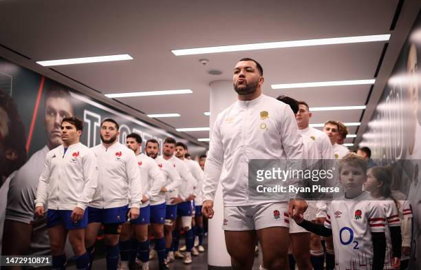 Captain Ellis Genge of England, holding the hand of a mascot, looks on as they line up in the tunnel prior to the Guinness Six Nations Rugby match...