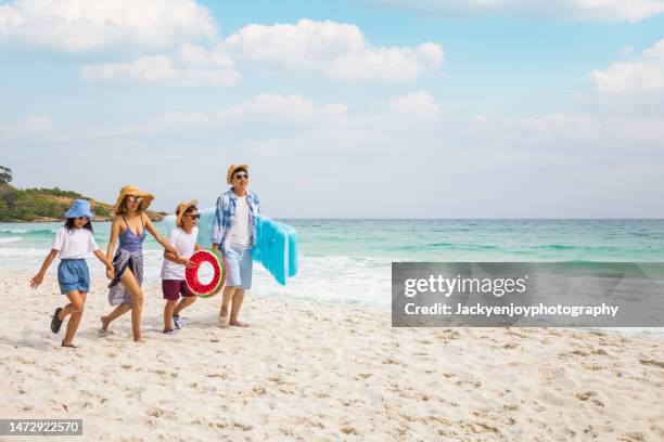 parents with children enjoying vacation on beach - ankle deep in water - fotografias e filmes do acervo