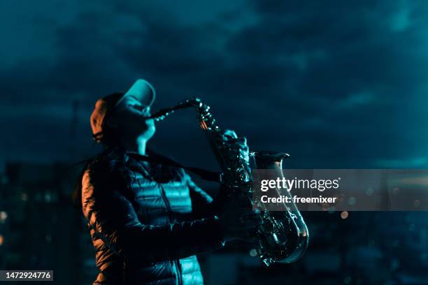 saxophonistin bei nacht - smooth jazz stock-fotos und bilder