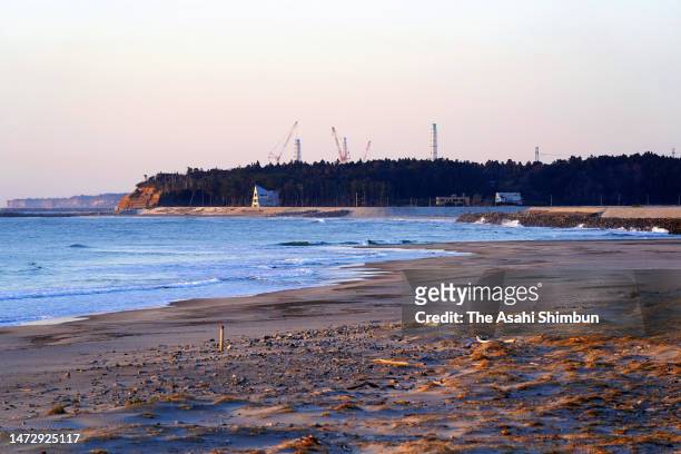 Exhaust stacks of Tokyo Electric Power Co's Fukushima Daiichi Nuclear Power Plant is seen from a beach at Ukedo district on the 12th anniversary of...