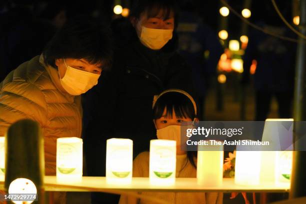 People visit former Okawa Elementary School where candle-lit lanterns are lit on the 12th anniversary of the Great East Japan Earthquake and...