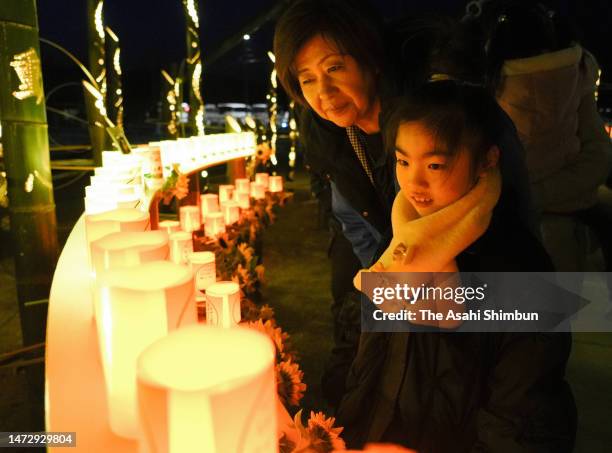 People visit former Okawa Elementary School where candle-lit lanterns are lit on the 12th anniversary of the Great East Japan Earthquake and...